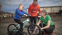 Sustrans schools officer with dad and son on bike