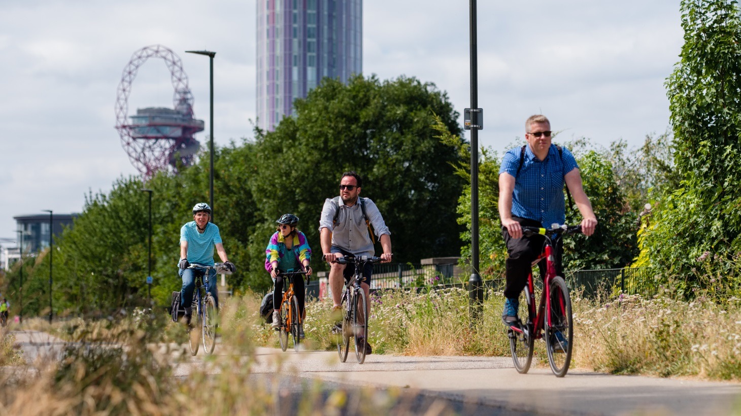 A group of people cycle along a Greenway in London
